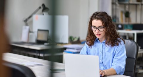 Young business woman worker working using laptop in modern office sit at desk.